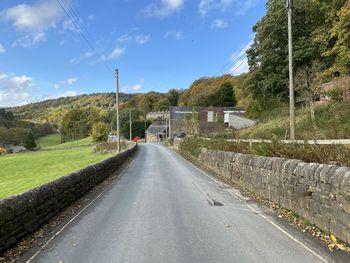 Looking down, midgehole road, with dry stone walls, fields and trees near, hebden bridge, uk