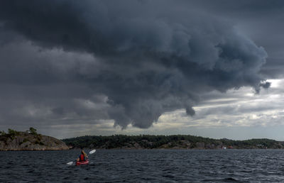 Scenic view of kayaker against sky