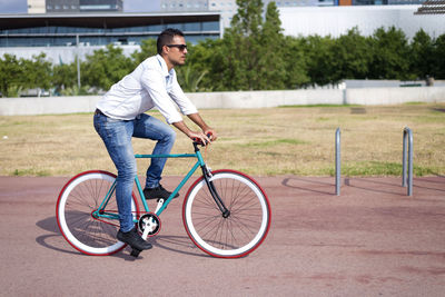 Low section of man riding bicycle on road