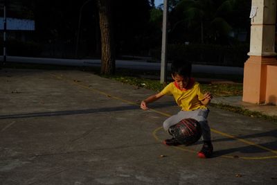 Full length of boy playing on road at night