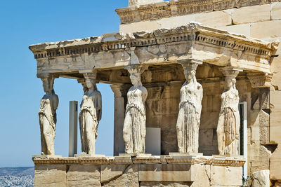 View of old building with statues against sky