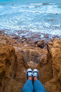 Low section of person on rock at beach