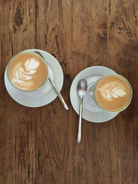 Directly above shot of coffee cup on wooden table