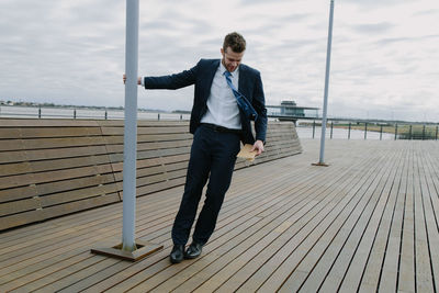 Full length of man on railing against sky