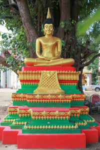 Statue of buddha outside temple against building