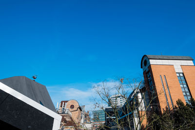 Low angle view of buildings against blue sky