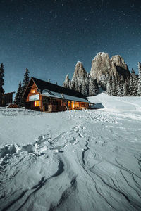 Snow covered houses against sky at night