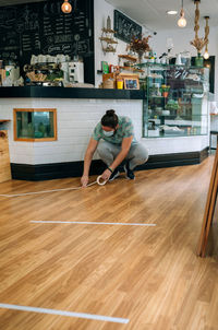 Boy sitting on hardwood floor at home