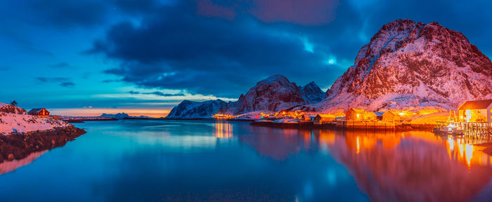 Scenic view of lake and snowcapped mountains against sky during sunset