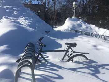 Snow covered bicycle against mountain