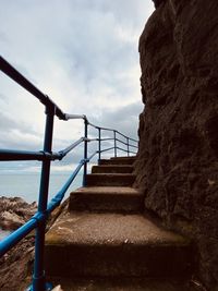 Staircase by sea against sky