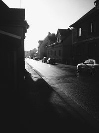 Cars on street in city against sky