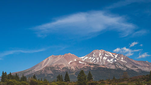 Scenic view of snowcapped mountains against blue sky