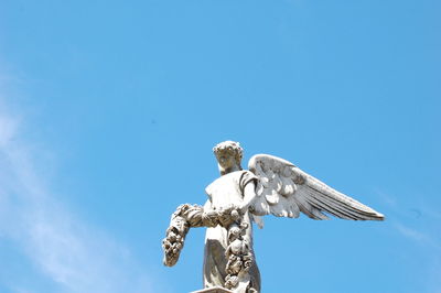 Low angle view of statue against blue sky