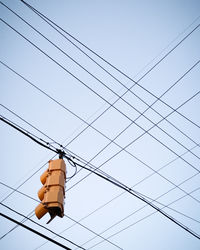 Low angle view of power lines against clear sky