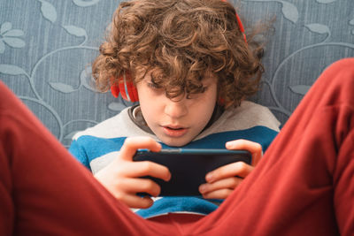 Kid playing game consolle stay at home.