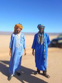 Full length of woman standing against blue sky