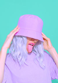 Portrait of woman with pink face against blue background