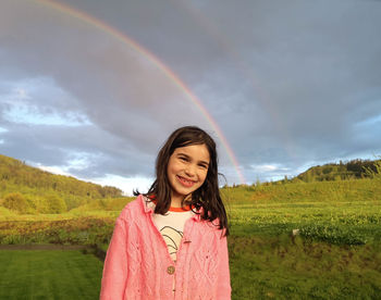 Portrait of smiling young woman standing on field