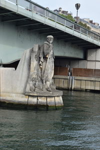 Statue by river against building