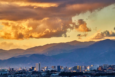 High angle view of townscape and mountains against sky during sunset
