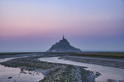 Scenic view of mont saint-michel against clear sky at dawn.