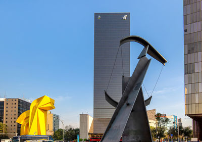 Low angle view of modern buildings against clear blue sky