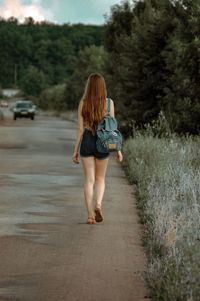 Rear view of woman walking on road