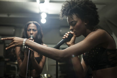 Young women singing in a recording studio