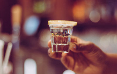 Close-up of hand holding shotglass