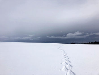 Scenic view of snow covered land against sky