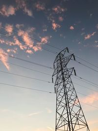 Low angle view of silhouette electricity pylon against sky