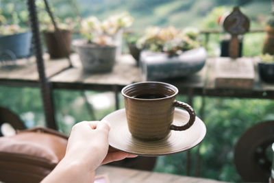 Person holding coffee cup on table