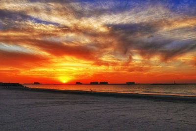 Scenic view of sea against dramatic sky during sunset