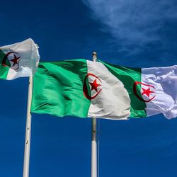 Low angle view of flags against blue sky