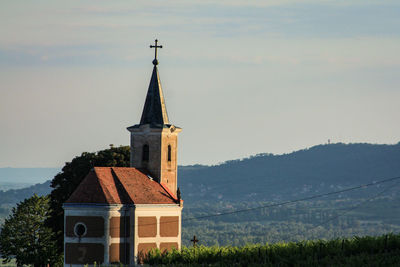Tower by building against sky