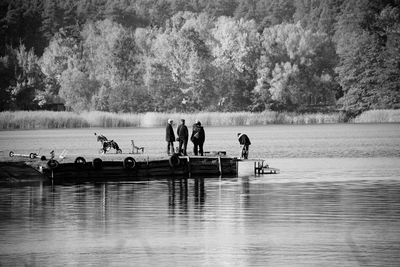 People standing on pier by lake