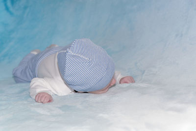 Rear view of boy lying on bed