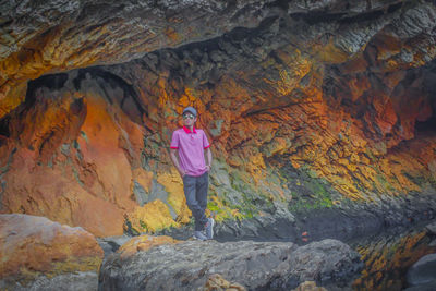 Portrait of man wearing sunglasses standing on rock formation