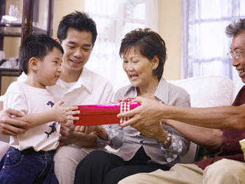 Family giving gift to boy at home