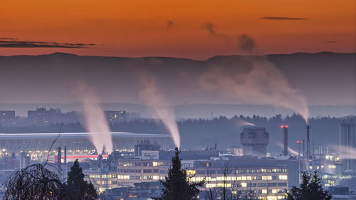 Panoramic view of illuminated city against sky during sunset