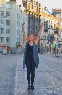 Portrait of smiling young woman standing in city