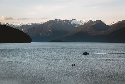 Scenic view of lake by mountains against sky