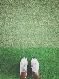 Low section of woman standing on field