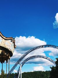 Low angle view of ferris wheel against cloudy sky