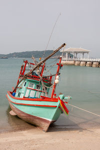 Fishing boat on beach against clear sky