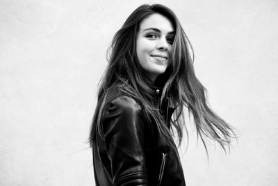 Portrait of smiling woman standing against white background