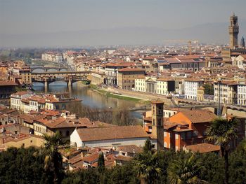 High angle view of townscape by river against sky