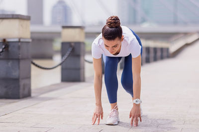 Young brunette woman running on asphalt road in summer park. active sporty caucasian female 