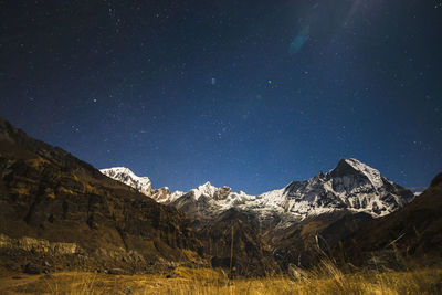 Low angle view of snowcapped mountains against sky